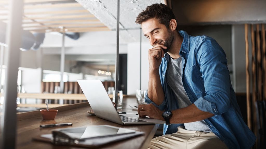 Man in coffee shop, laptop and small business owner, entrepreneur in hospitality management and connectivity. Happy male professional, cafe franchise and wireless connection with digital admin on pc